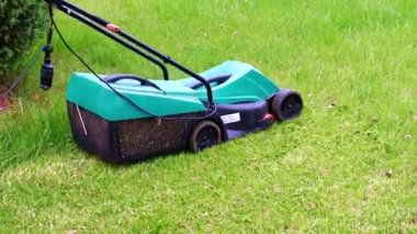 Çimleri biçerken elektrikli bahçe çim biçme makinesi hareketi