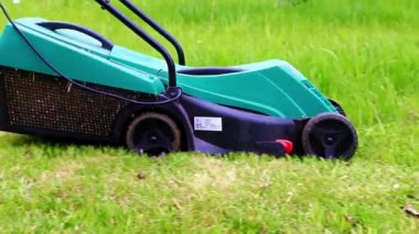Çimleri biçerken elektrikli bahçe çim biçme makinesi hareketi