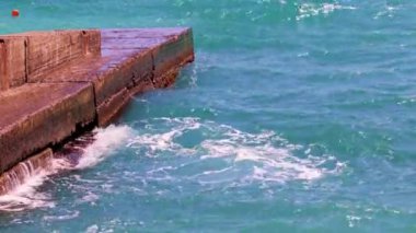 Harap olmuş beton dalgalar ve deniz dalgaları kıyıda