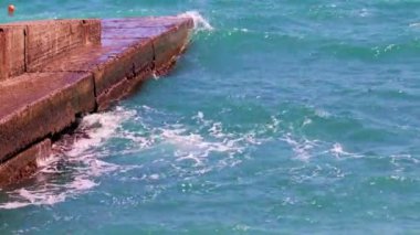 Harap olmuş beton dalgalar ve deniz dalgaları kıyıda