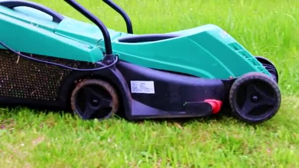 緑の芝生を刈るときの電庭芝刈り機の動き — ストック動画