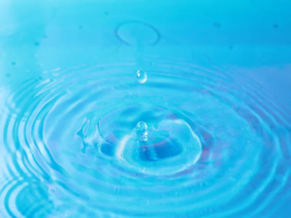 一滴水滴在清澈的液体上 形成美丽的图案 — 图库照片