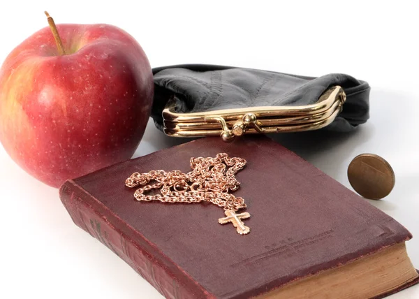金貨付きの財布の隣に熟したリンゴと黄金の十字架付きの宗教書 — ストック写真