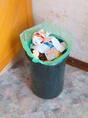 Yiyecek ve ev atığı dolu plastik bir kova.