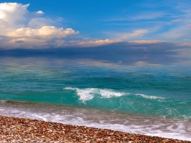 Kumsalı ve karanlık bir akşam gökyüzü olan güzel deniz manzarası.