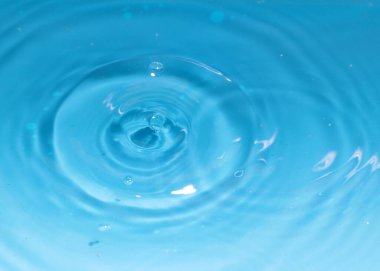 Düşerken bir damla temiz su sıvının yüzeyinde süslü desenler oluşturur.