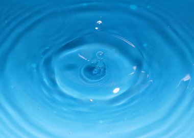 Düşerken bir damla temiz su sıvının yüzeyinde süslü desenler oluşturur.