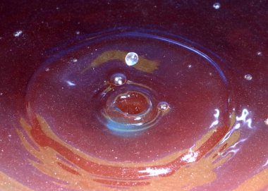 Mikroplarla enfekte olmuş kirli bir su damlası kirlenmiş sıvının yüzeyine düşer.