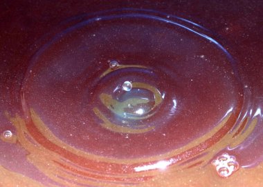 Kimyasal sıvının yüzeyine bir damla kirli su düşer ve kırılır.