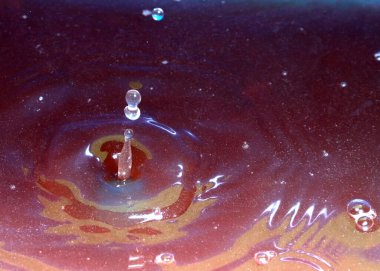 Kimyasal sıvının yüzeyine bir damla kirli su düşer ve kırılır.