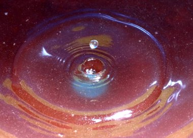 Kimyasal sıvının yüzeyine bir damla kirli su düşer ve kırılır.