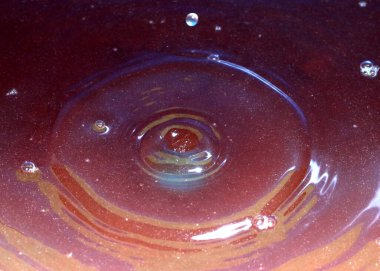 Kimyasal sıvının yüzeyine bir damla kirli su düşer ve kırılır.