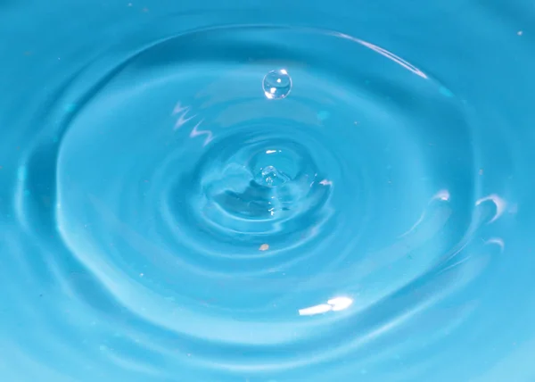 一滴纯净的水落到液体表面时就会形成一个图案 — 图库照片