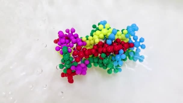 液体の表面に悪性疾患の原因となるウイルス分子のプラスチックモデル — ストック動画