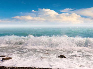 Deniz kıyısının çakıl taşlı kumsalında güzel mavi gökyüzü