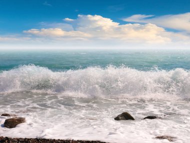 Deniz kıyısının çakıl taşlı kumsalında güzel mavi gökyüzü