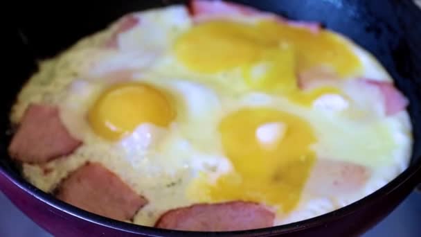 le processus de préparation des œufs frits avec saucisse pour le petit déjeuner du matin 