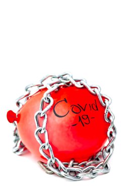 COVID etrafındaki çelik zincir - 19 şişirilmiş kırmızı balon. Sığ alan derinliğine sahip seçici odak.