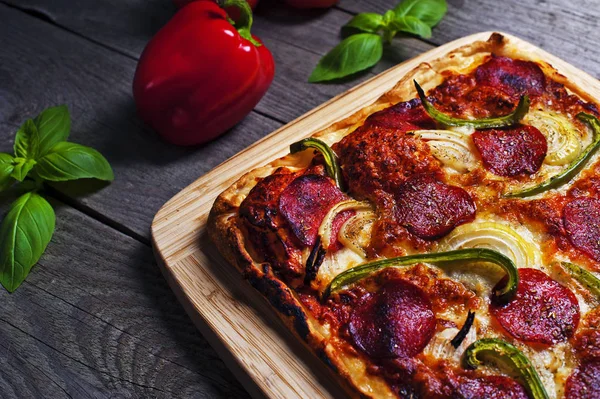 Biberli ahşap bir masa üzerinde İtalyan ev yapımı pizza