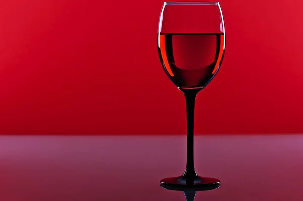 Bicchiere di vino rosso francese su sfondo rosso Foto Stock