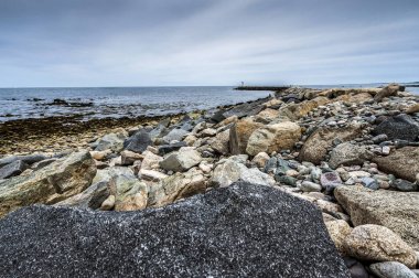 Bulutlu gökyüzü arka plan üzerinde güzel kayalık deniz manzarası 