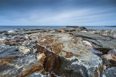 Bulutlu gökyüzü arka plan üzerinde güzel kayalık deniz manzarası 