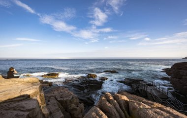 North America, Acadia - January 14, 2018: Woman enjoying view of ocean in Acadia National Park clipart