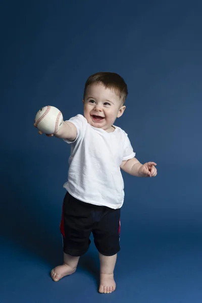 Söt Pojke Som Håller Baseball Bollen Poserar Mörkblå Bakgrund Stockbild