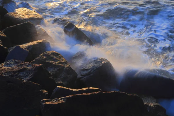 Verschwommene Meereswelle Kracht Bei Sonnenaufgang Über Felsen Auf Dem Cobb — Stockfoto