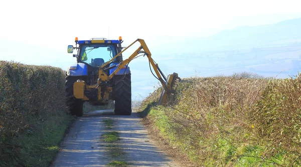 Traktör takılı hedge kesici Doğu Devon'da bir ülke yolda