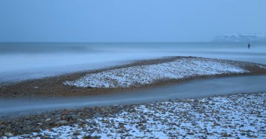 Bulanık deniz dalgaları kasaba Seaton Jurassic Coast Devon'da yakınındaki karlı bir plajda