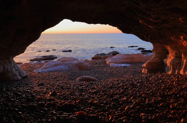 Sunrise over the Jurassic Coast natural World Heritage Site, seen from the sea cave near village of Beer in Devon