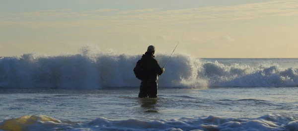 Surf fishing on the Jurassic Coast near Seaton in Devon