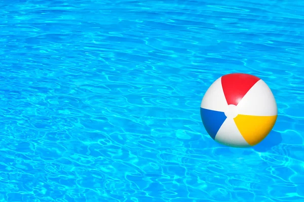 Bola colorida flutuando na piscina — Fotografia de Stock