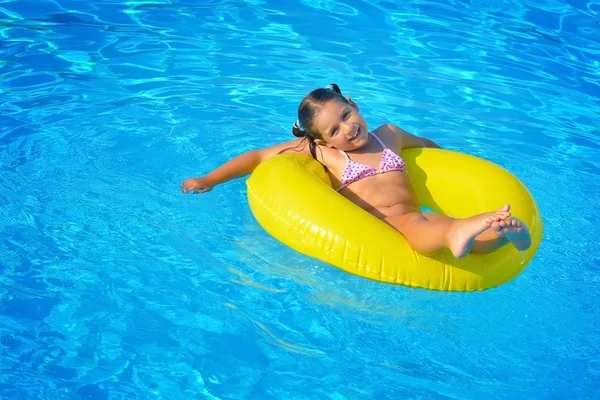 Menina criança real relaxante na piscina — Fotografia de Stock