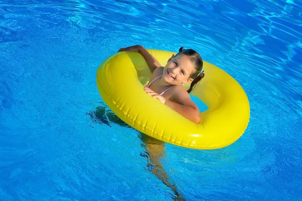Menina criança real relaxante na piscina — Fotografia de Stock