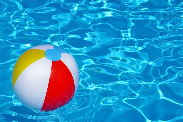 Colorful inflatable ball floating in swimming pool — Stock Photo, Image