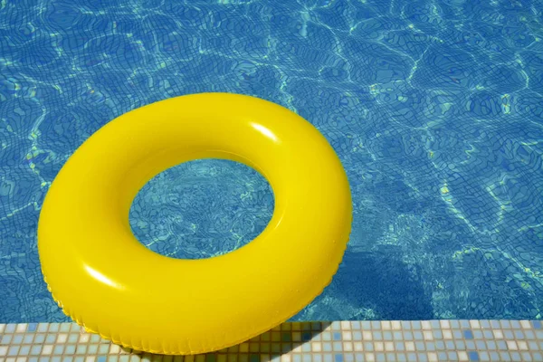 Colorful inflatable tube floating in swimming pool — Stock Photo, Image