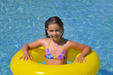 Çok tatlı bir kız, yüzme havuzunda dinleniyor, yaz tatili konsepti.