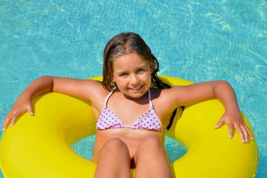 Çok tatlı bir kız, yüzme havuzunda dinleniyor, yaz tatili konsepti.