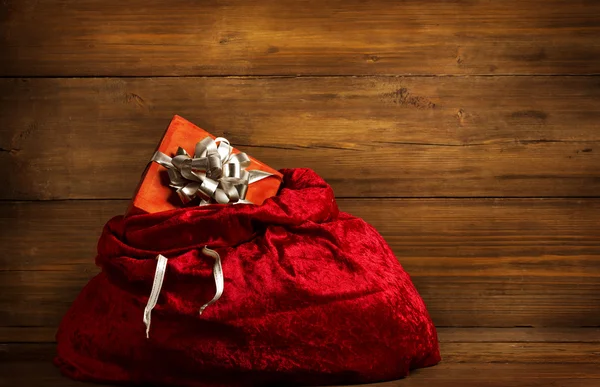 Sac de Père Noël Boîte cadeau cadeau plein présent, sac de Noël sur bois — Photo