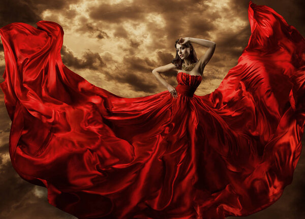 Женщина танцует в красном платье, модель танца с летающим платьем
