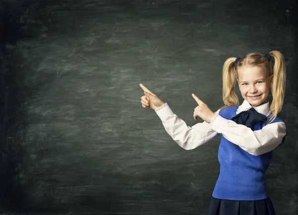 Niña de la escuela infantil señalando pizarra, estudiante de niño sobre tablero negro — Foto de Stock