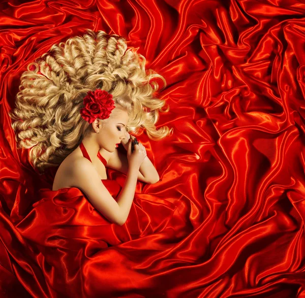 Arte di bellezza dei capelli, Donna bella acconciatura riccia, Modello di moda bionda dormire sul tessuto di seta rossa — Foto Stock