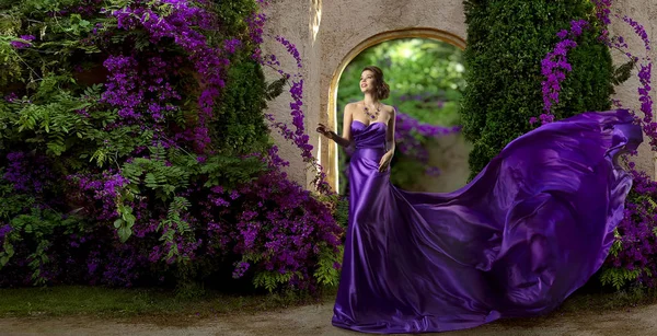 Modelo de moda vestido púrpura, mujer vestido de seda largo, flores de jardín violeta — Foto de Stock