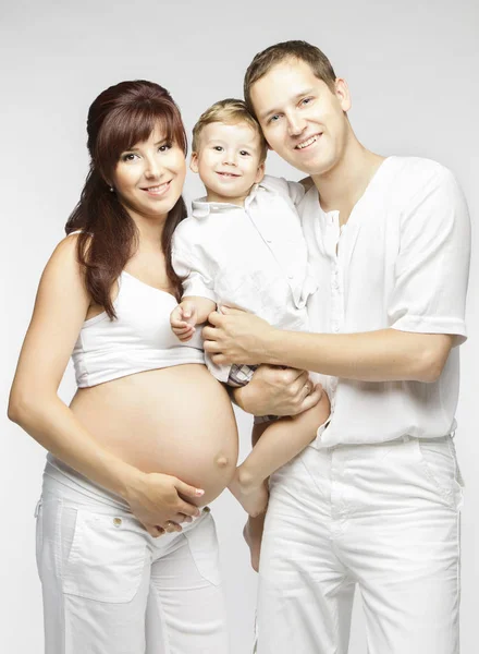Ευτυχισμένη οικογένεια, έγκυος μητέρα, πατέρας και παιδί στα λευκά, οι γονείς με παιδί — Φωτογραφία Αρχείου