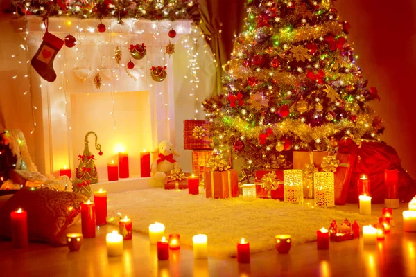 Χριστουγεννιάτικο δέντρο, παρουσιάζει δώρα και τζάκι στο σπίτι διακοπών δωμάτιο, φως κεριών — Φωτογραφία Αρχείου