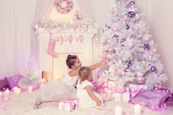 Los niños de Navidad que decoran el árbol de Navidad, el niño y las niñas —  Fotos de Stock