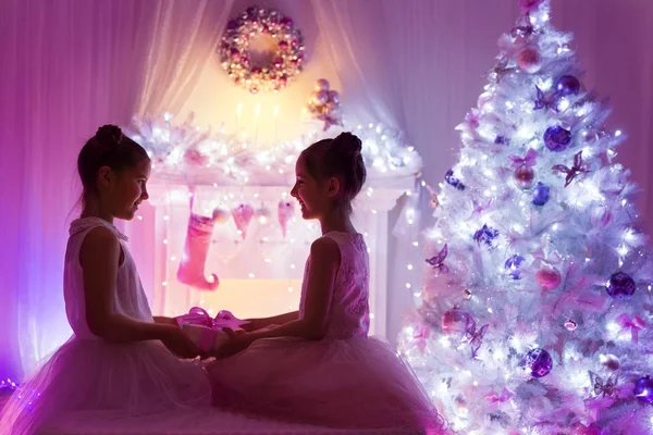 Weihnachtsmädchen, glückliche Kinder beschenken, Weihnachtsbaum anzünden — Stockfoto