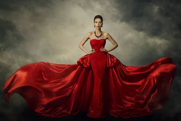 Modèle de mode robe d'art, élégante femme debout dans la robe rétro rouge, tissu de soie flottante — Photo